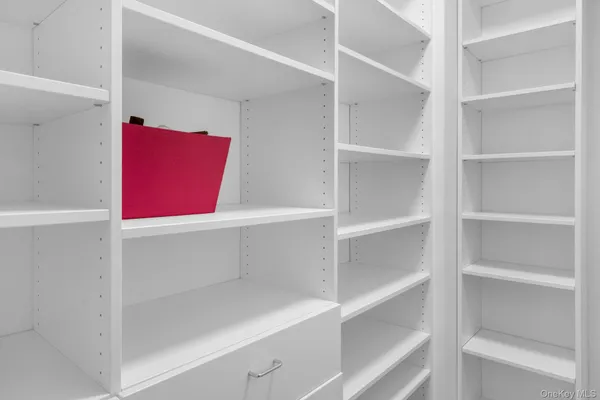 a bedroom with a bed a chandelier and dresser