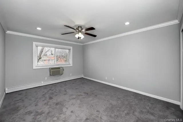an empty room with windows and ceiling fan