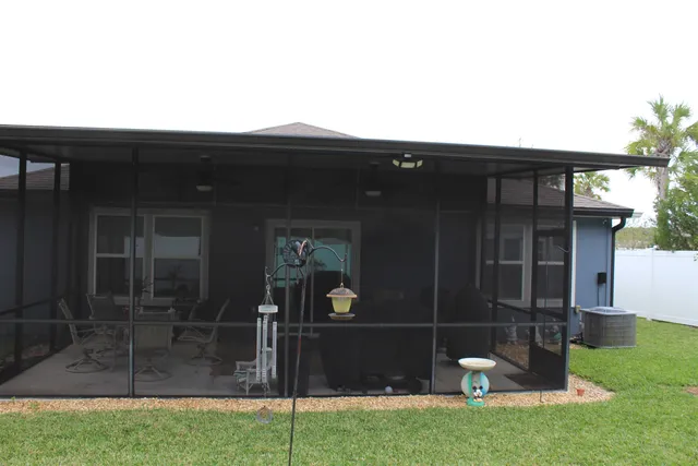 a view of backyard with brick wall and a large tree