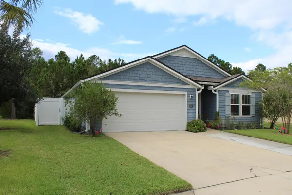 a front view of a house with a garden and plants