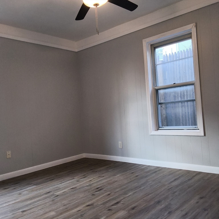 212-218 Lowell Street, Unit 1E Fall River, MA 02721 - Photo 7 of 10 a view of an empty room with wooden floor and a window