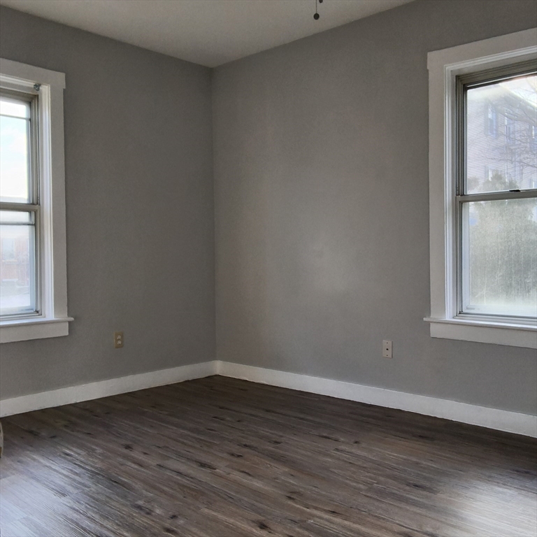 212-218 Lowell Street, Unit 1E Fall River, MA 02721 - Photo 9 of 10 an empty room with wooden floor and windows