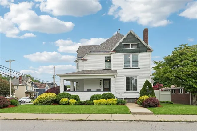 a front view of yellow house with garden