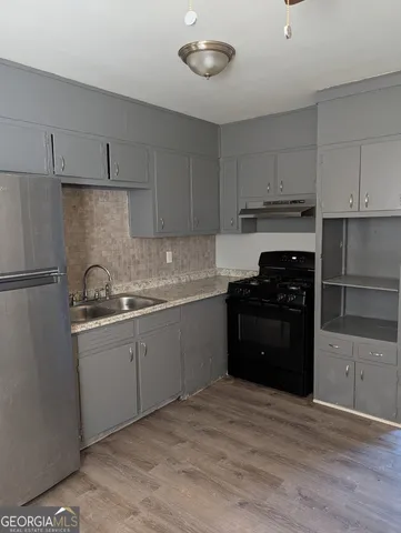 a kitchen with a sink appliances and cabinets