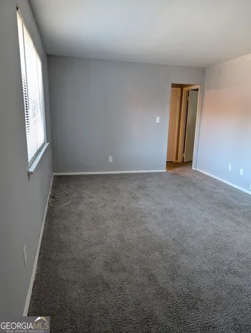 an empty room with windows and closet