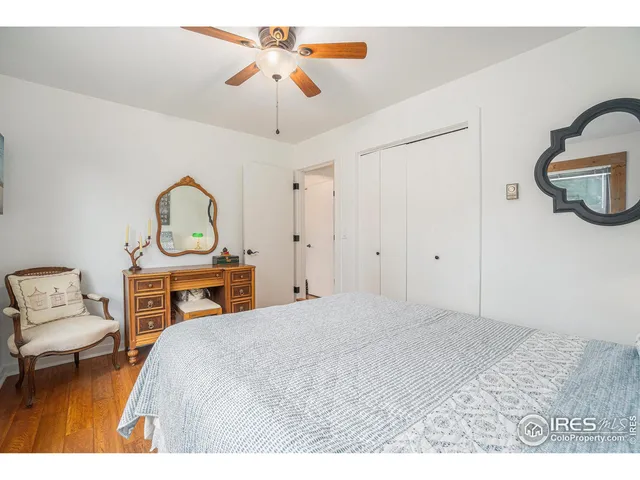 a bedroom with a bed a chandelier and dresser