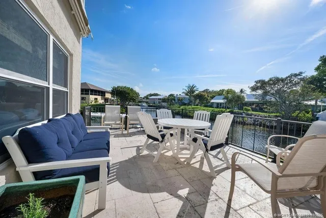 a roof deck with table and chairs couches with wooden floor and fence