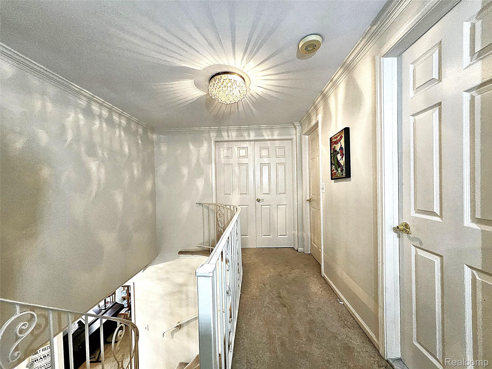 1114 Chaffer Drive Rochester, MI 48306 - Photo 11 of 50 Upper-level hallway featuring a decorative flush-mount ceiling light, crown molding, and multiple paneled doors