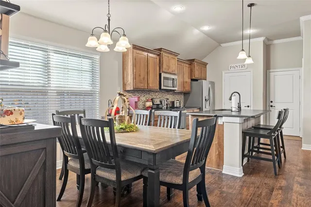 a kitchen with kitchen island granite countertop a stove a sink and a microwave
