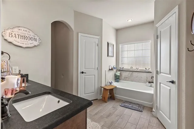 a bathroom with a granite countertop sink and a mirror
