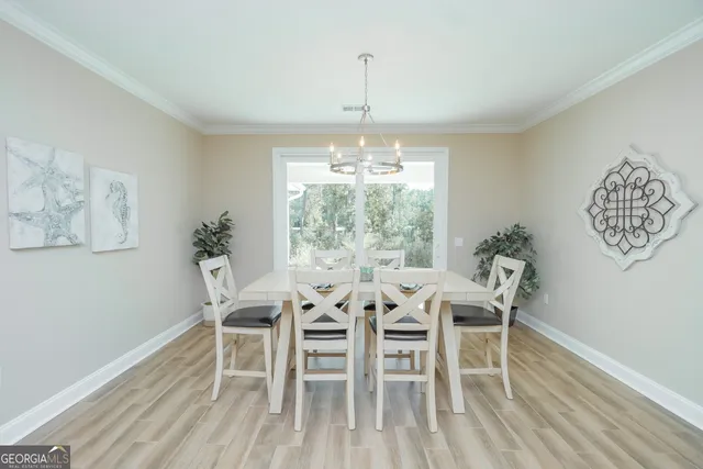 a dining room with furniture a chandelier and wooden floor
