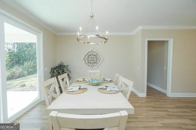 a view of a dining room with furniture a chandelier and wooden floor