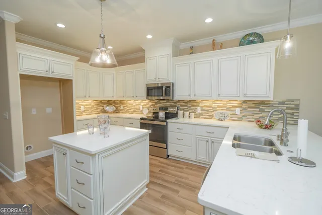 a kitchen with a sink stove cabinets and wooden floor