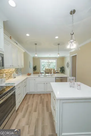 a large kitchen with kitchen island a sink stainless steel appliances and cabinets