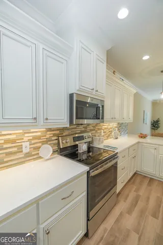 a kitchen with stainless steel appliances granite countertop a stove a sink and a microwave