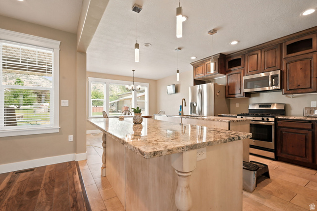 580 North 300 East Logan, UT 84321 - Photo 30 of 74 Kitchen featuring a large central island with a light-colored stone countertop and decorative corbels