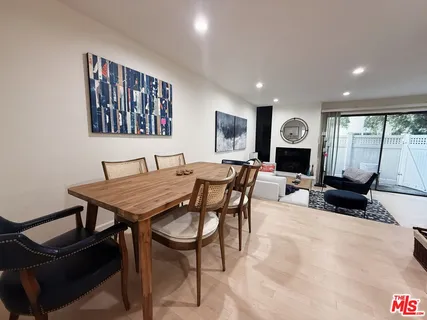 a living room with furniture a rug and wall painting