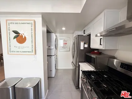 a kitchen with stainless steel appliances granite countertop a refrigerator and a stove top oven