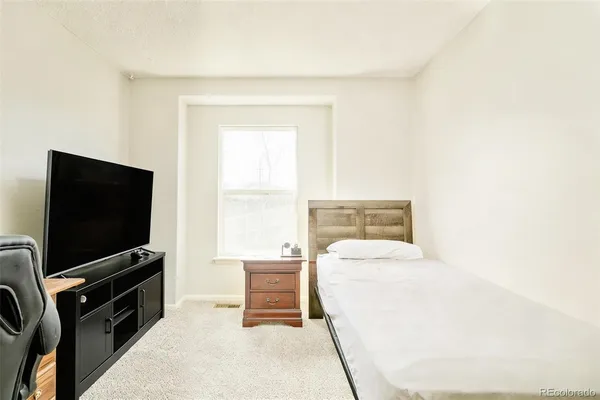 a bedroom with a bed and a flat screen tv