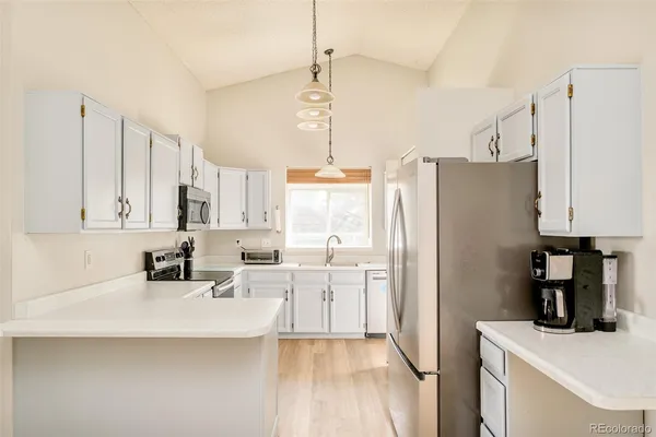 a kitchen with stainless steel appliances a refrigerator sink and white cabinets
