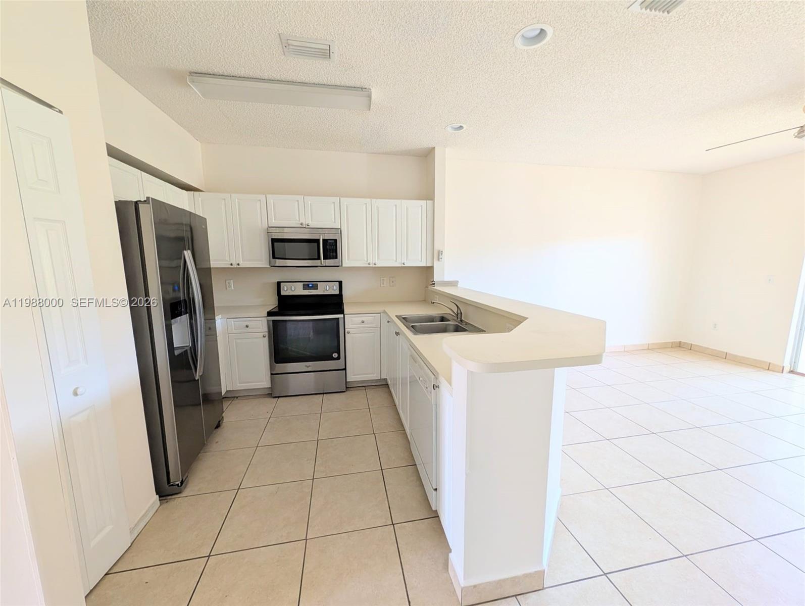 2320 Southeast 23rd Road, Unit 2320 Homestead, FL 33035 - Photo 5 of 11 a kitchen with stainless steel appliances a refrigerator sink and microwave