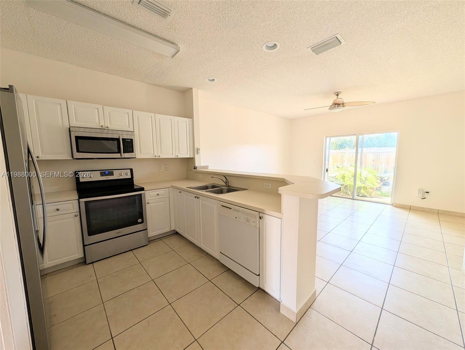 2320 Southeast 23rd Road, Unit 2320 Homestead, FL 33035 - Photo 6 of 11 a kitchen with a stove a sink and a microwave