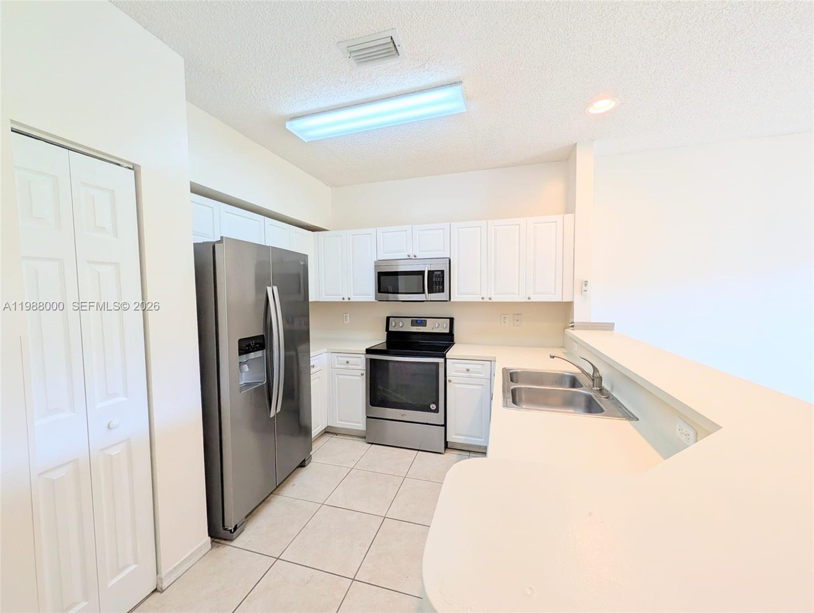 2320 Southeast 23rd Road, Unit 2320 Homestead, FL 33035 - Photo 7 of 11 a kitchen with granite countertop a refrigerator and a stove