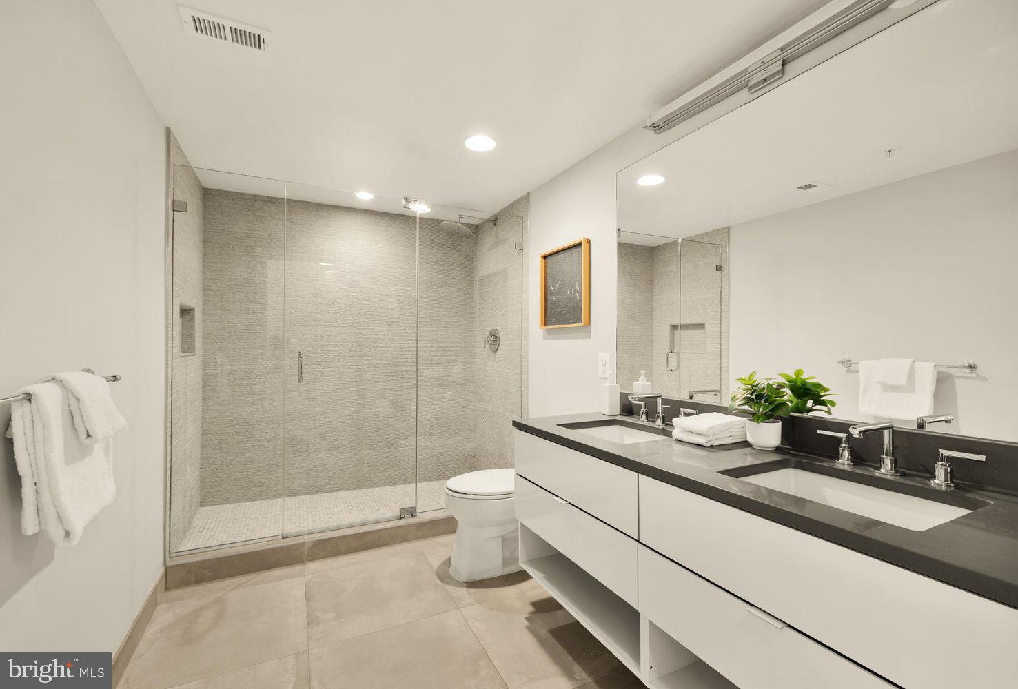 1311 13th Street Northwest, Unit 305 Washington, DC 20005 - Photo 20 of 29 a bathroom with a double vanity sink toilet and shower