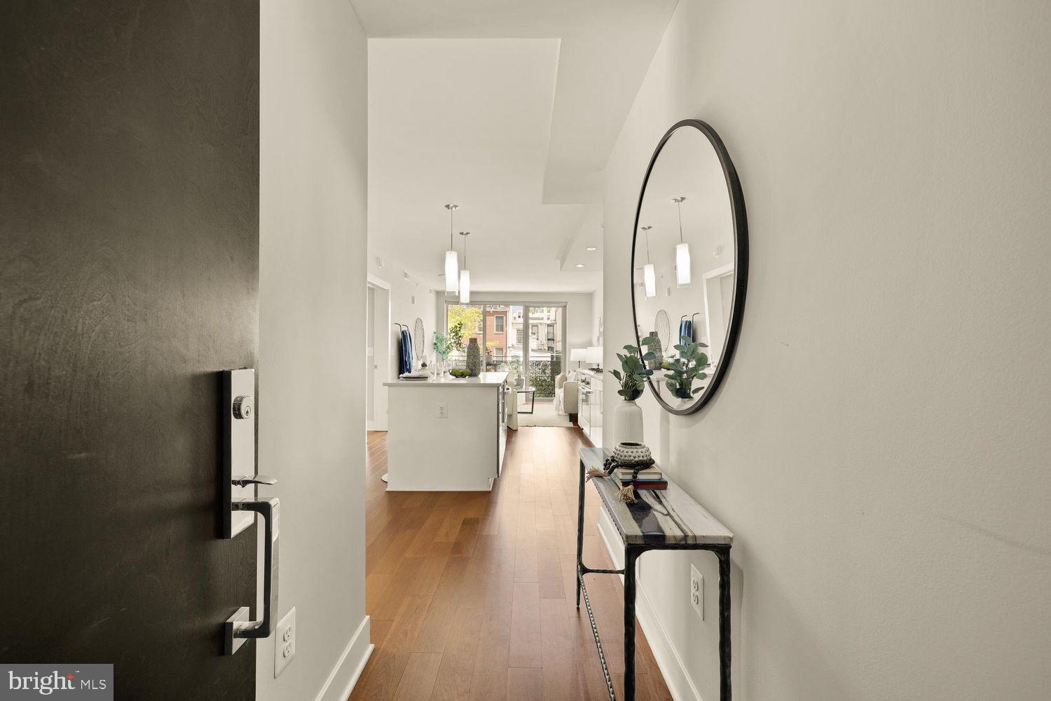 1311 13th Street Northwest, Unit 305 Washington, DC 20005 - Photo 5 of 29 a picture of a room with wooden floor mirror and a potted plant