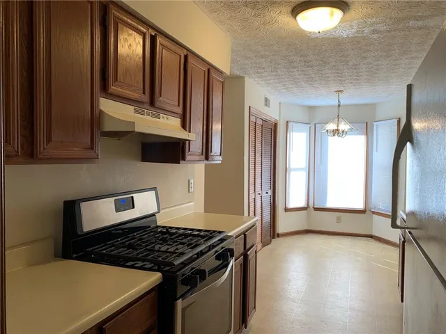 a kitchen with granite countertop a stove and a wooden floor
