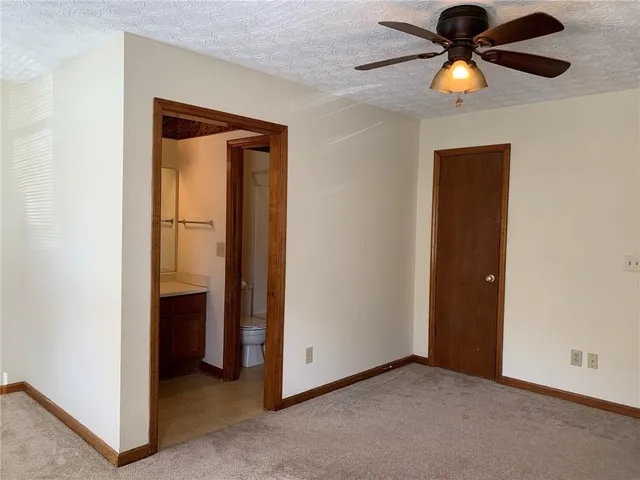 an empty room with closet and a chandelier fan