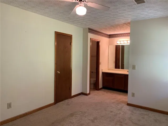 an empty room with window and bathroom