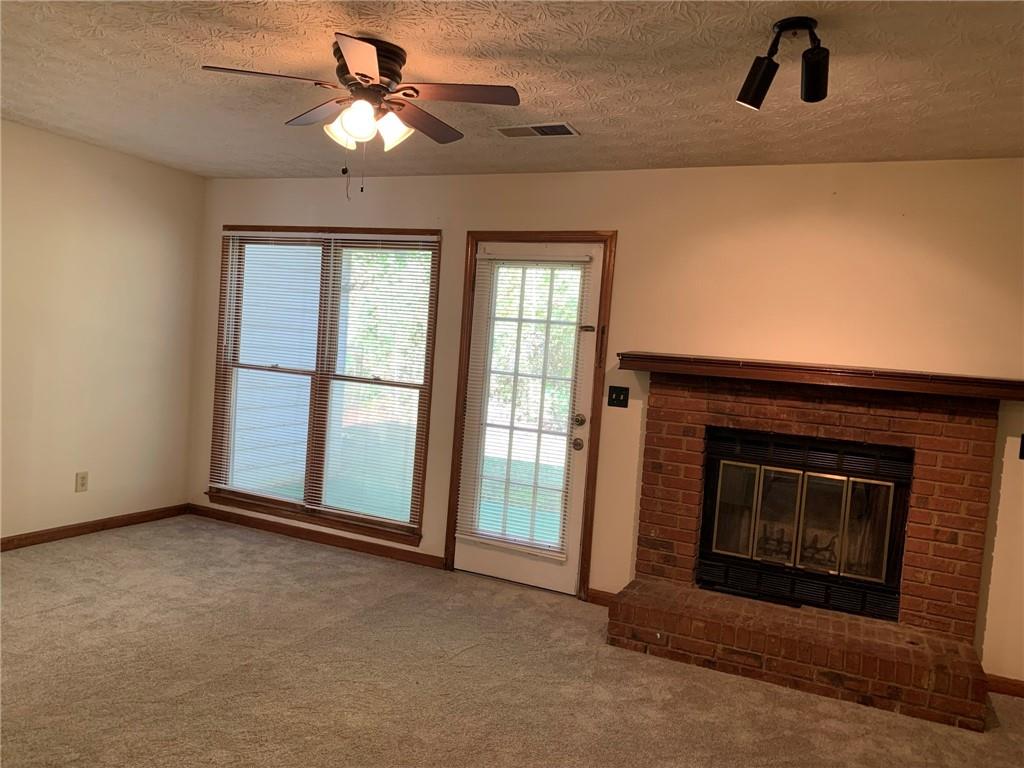 1103 Booth Court Southwest, Unit 1103 Marietta, GA 30008 - Photo 7 of 30 a view of an empty room with chandelier fan and fire place