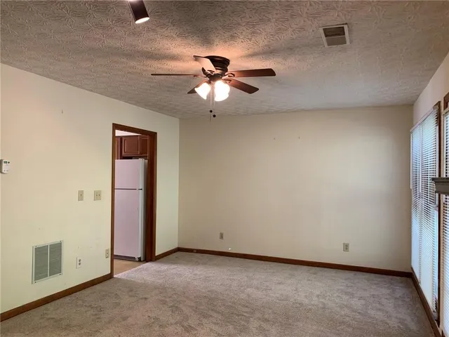 an empty room with closet and a chandelier fan