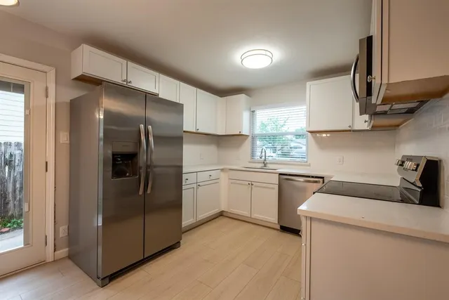 a kitchen with a refrigerator sink and cabinets