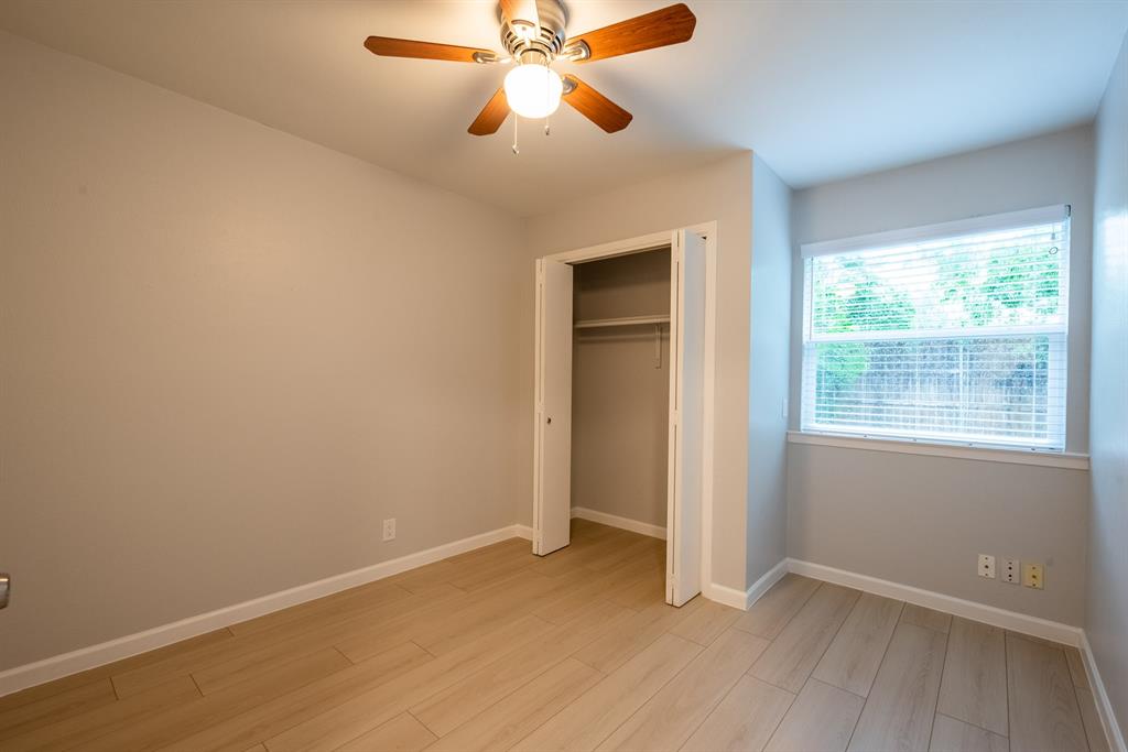 8708 Pineridge Drive, Unit A Austin, TX 78729 - Photo 11 of 15 an empty room with windows and fan