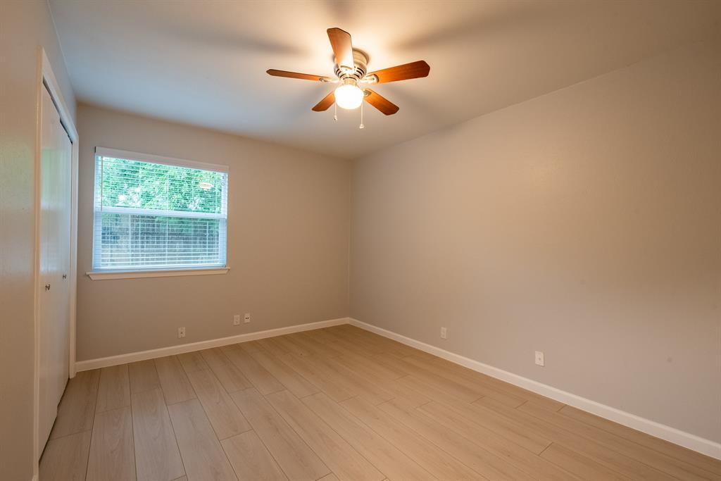 8708 Pineridge Drive, Unit A Austin, TX 78729 - Photo 12 of 15 an empty room with wooden floor and windows