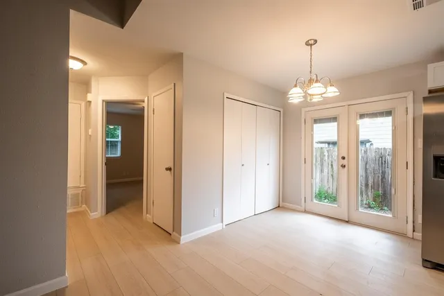 a view of a hallway with wooden floor and chandelier