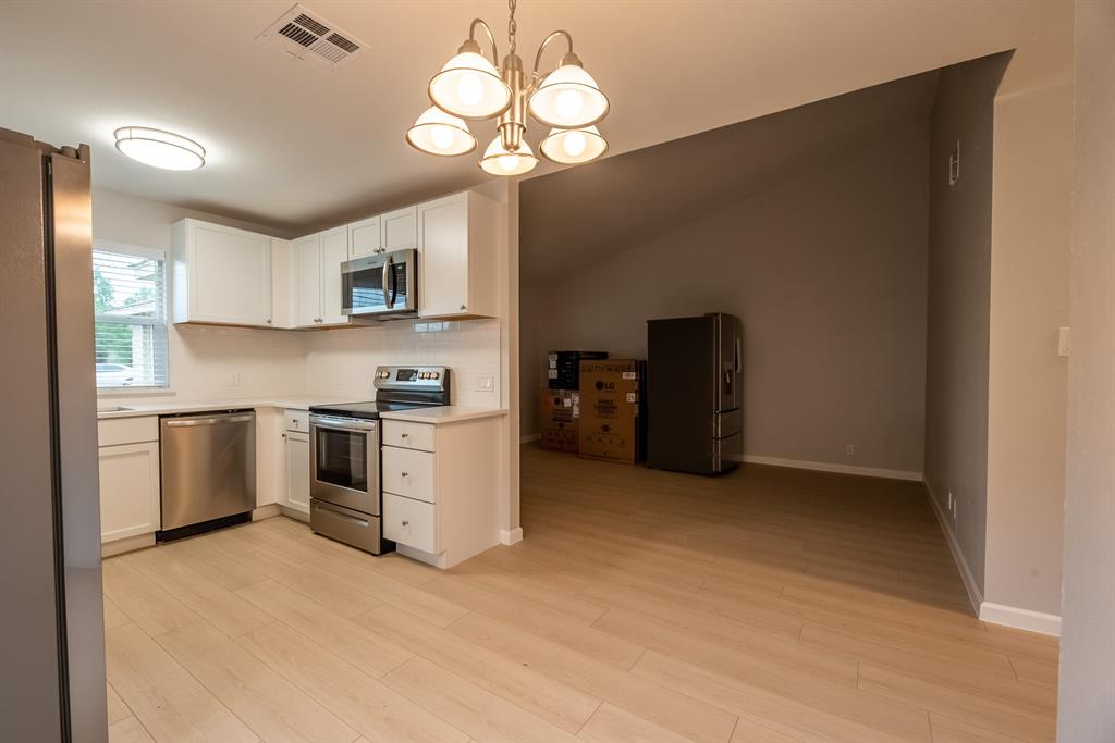 8708 Pineridge Drive, Unit A Austin, TX 78729 - Photo 8 of 15 a kitchen with a stove cabinets and a refrigerator