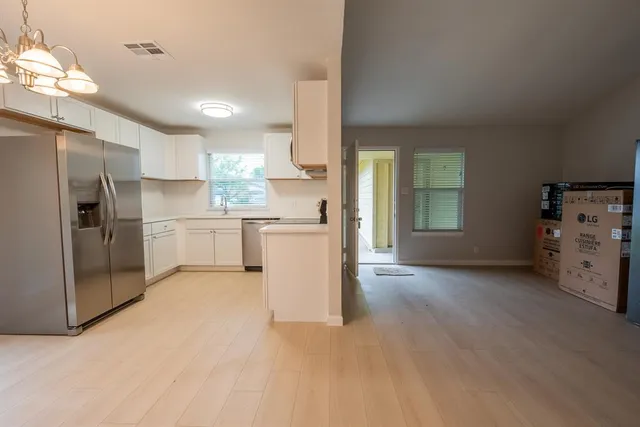 a view of a kitchen with refrigerator and window