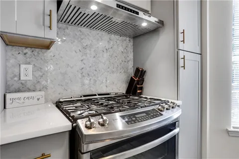 a stove top oven sitting inside of a kitchen