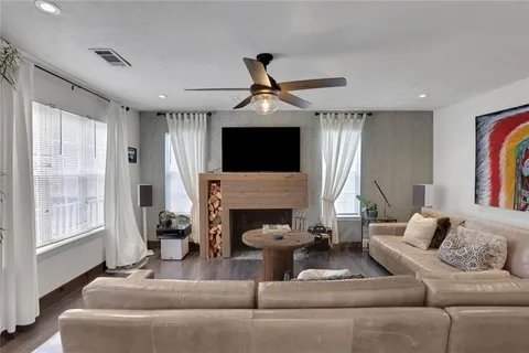 a living room with furniture a fireplace and a flat screen tv