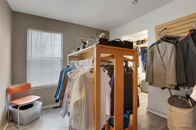 a view of walk in closet with clothes and shoes