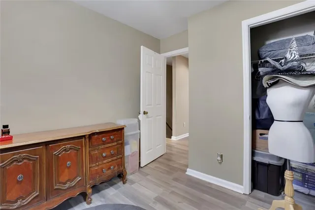 a view of a hallway with closet and wooden floor