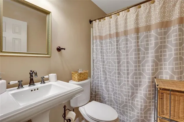 a bathroom with a sink a toilet and shower curtain