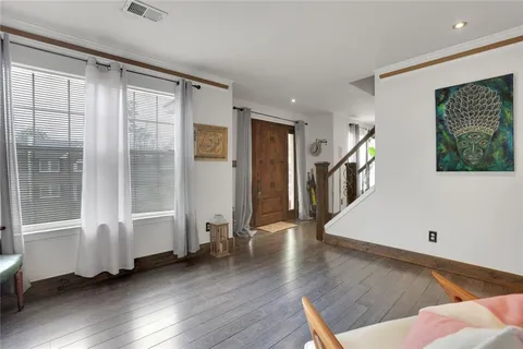 a view of a big room with wooden floor and windows