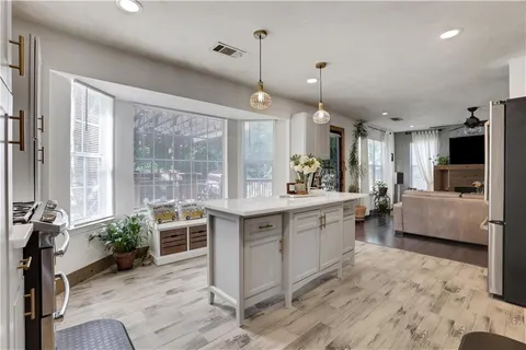 a large kitchen with kitchen island a large island in it