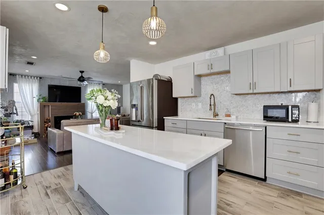 a kitchen that has a lot of cabinets in it and wooden floors