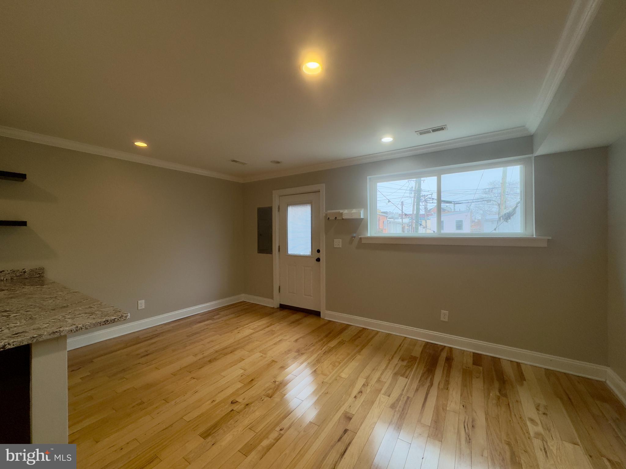 3533 Falls Road Baltimore, MD 21211 - Photo 15 of 20 a view of an empty room with wooden floor and a window