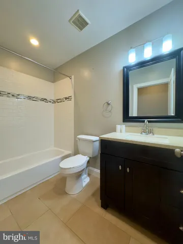 a bathroom with a double vanity sink toilet mirror and bathtub